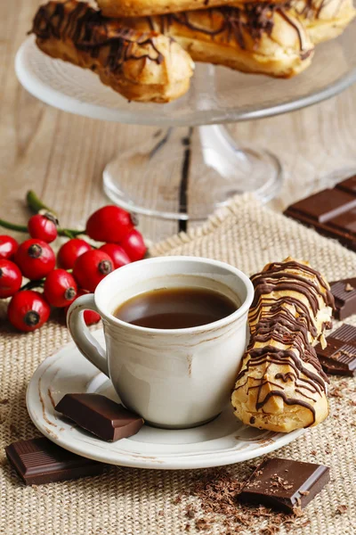 Cup of coffee and eclairs — Stock Photo, Image