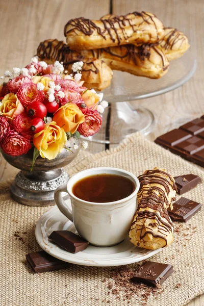 Cup of coffee and eclairs — Stock Photo, Image