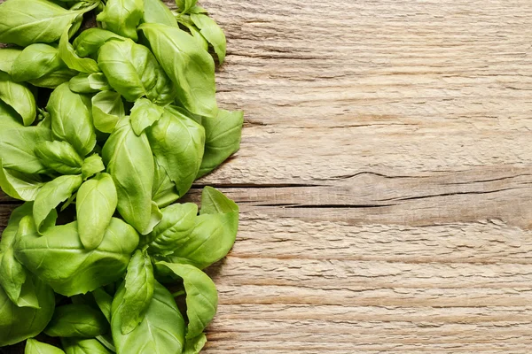 Hojas de albahaca sobre fondo de madera — Foto de Stock