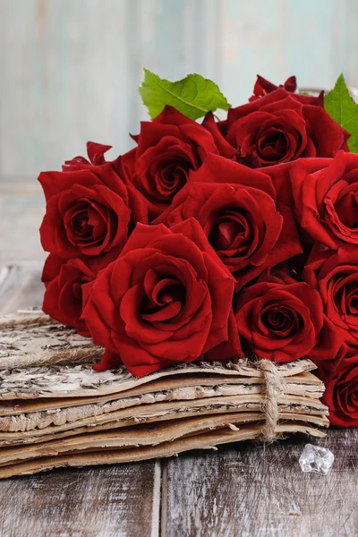 Ramo de rosas rojas sobre mesa de madera — Foto de Stock