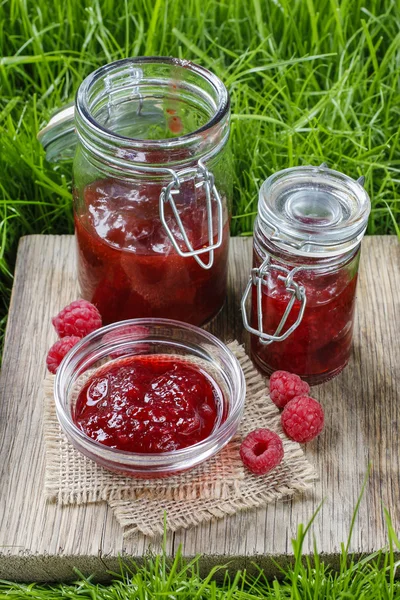 Raspberry jam on wooden tray in the garden — Stock Photo, Image