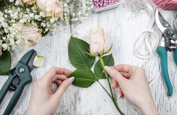 Florista no trabalho. Mulher fazendo buquê de rosas rosa . — Fotografia de Stock