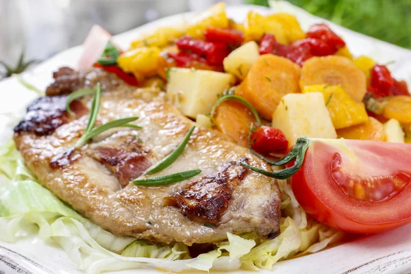 Joint of pork with baked potatoes and fresh vegetables — Stock Photo, Image