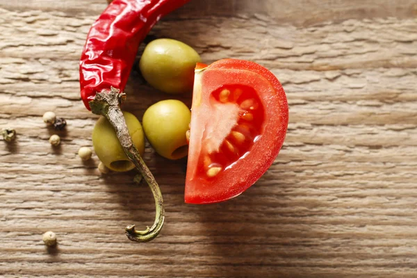 Italian cuisine: tomatoes, olives and basil leaves on wooden tab — Stock Photo, Image