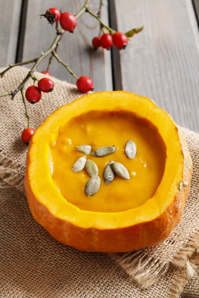 Creamy pumpkin soup on rustic wooden table — Stock Photo, Image