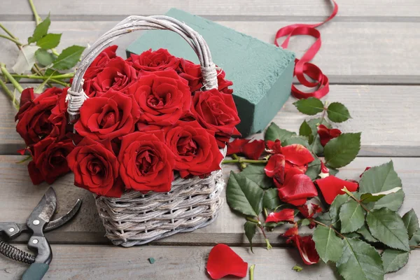 Mujer arreglando ramo de rosas rojas — Foto de Stock