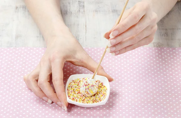 Woman decorating cake pops with colorful sprinkles — Stock Photo, Image