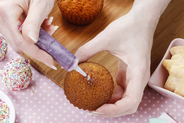 Woman decorating cake pops with colorful sprinkles — Stock Photo, Image