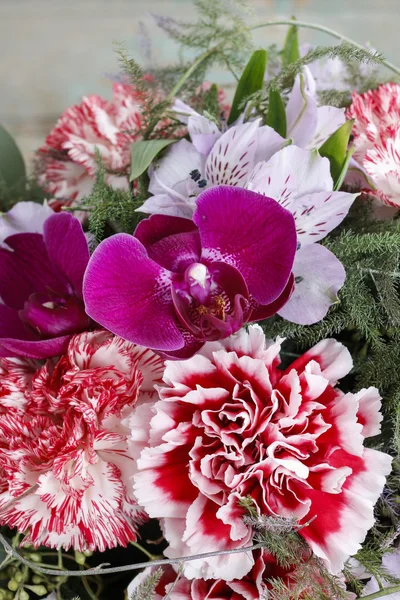 Buquê de cravos vermelhos e flores de orquídeas roxas — Fotografia de Stock