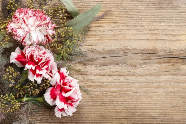 木材に赤と白のカーネーションの花 — ストック写真
