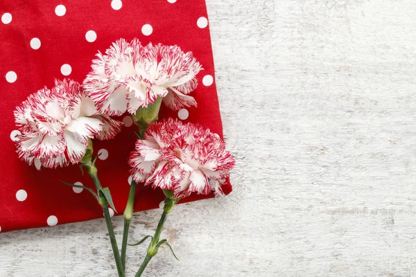 Rote und weiße Nelke Blumen auf Holz — Stockfoto
