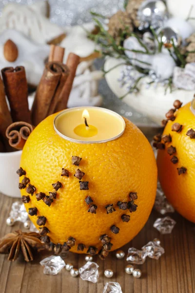 Апельсиновый шар со свечой, украшенной гвоздикой — стоковое фото