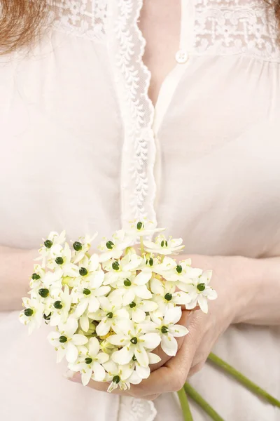 Frau mit einem Strauß winziger weißer Blüten (Ornithogalum arabic) — Stockfoto