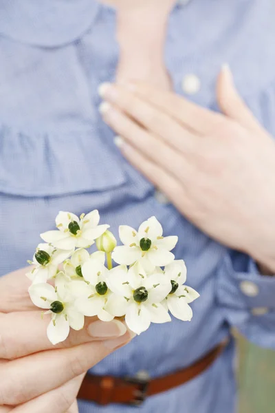 Frau mit einem Strauß winziger weißer Blüten (Ornithogalum arabic) — Stockfoto