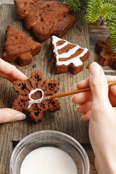 Decorating christmas gingerbread chocolate cookies with white ic — Stock Photo, Image