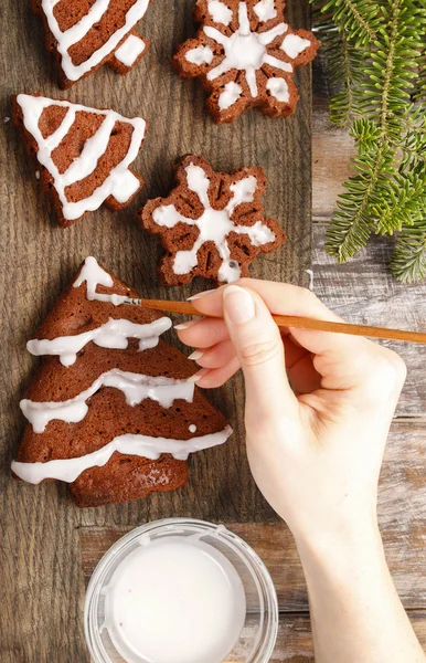 Decorating christmas gingerbread chocolate cookies with white ic — Stock Photo, Image