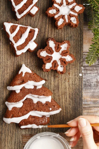 Decorating christmas gingerbread chocolate cookies with white ic — Stock Photo, Image