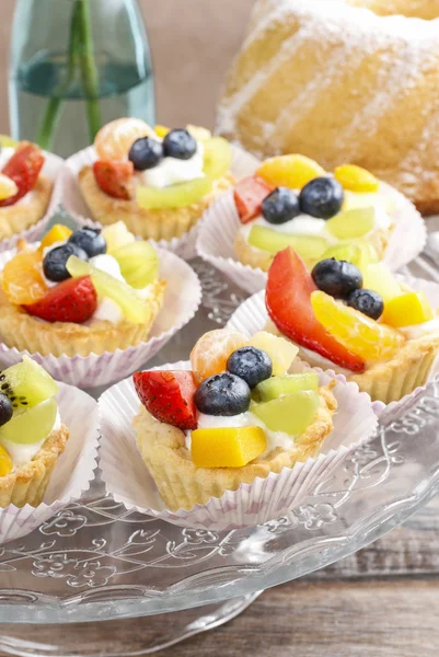 Cupcakes with cram and fresh fruits — Stock Photo, Image