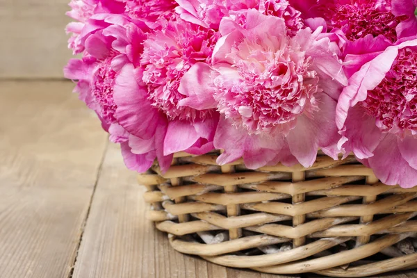 Καλάθι με αρκετά ροζ peonies, ξύλινα ρουστίκ φόντο, — Φωτογραφία Αρχείου
