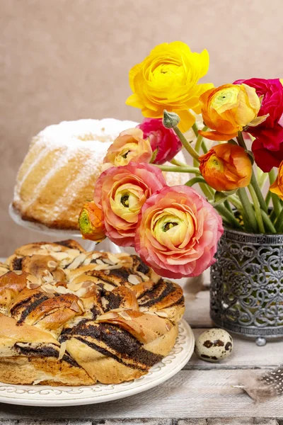 Poppy seed easter cake and bouquet of ranunculus flowers — Stock Photo, Image
