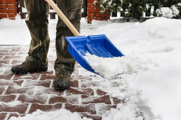 在暴风雪后从人行道上除雪的人 — 图库照片