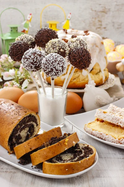 Chocolate cake pops and poppy seed cake on easter table — Stock Photo, Image
