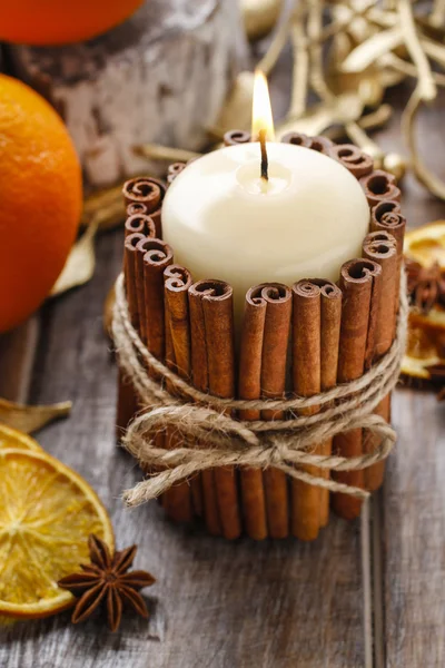 Candle decorated with cinnamon sticks — Stock Photo, Image