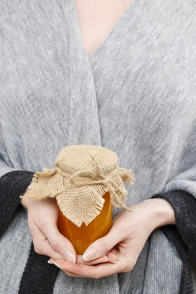 Mujer sosteniendo frasco de vidrio de miel — Foto de Stock