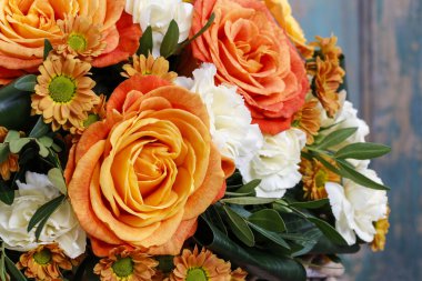 Bouquet of orange roses and ivory carnation flowers