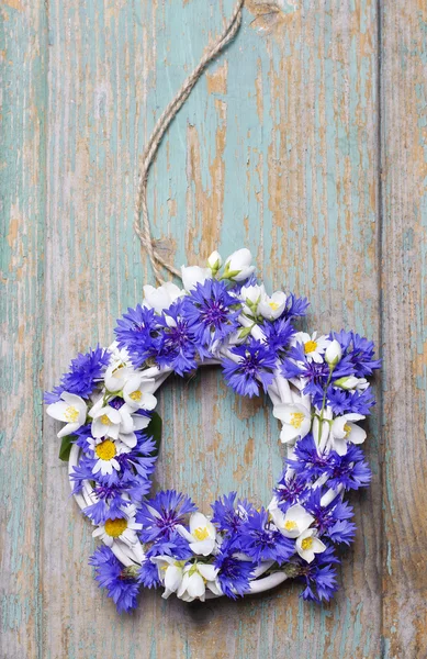 Wicker wreath decorated with cornflowers, chamomiles and jasmine — Stock Photo, Image