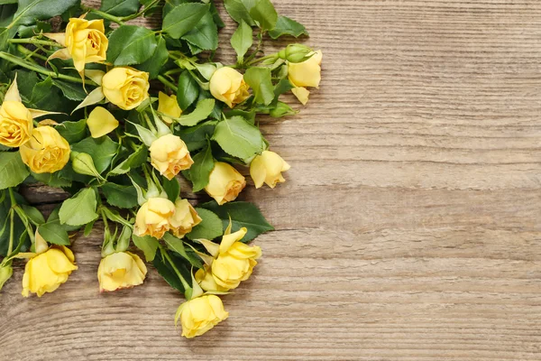 Gele rozen op houten achtergrond. — Stockfoto