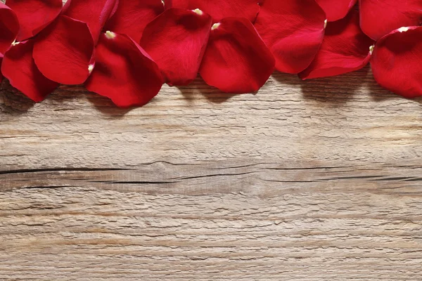 Petali di rosa rossa su sfondo di legno — Foto Stock