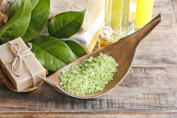 Green sea salt and bar of natural handmade soap on wooden table — Stock Photo, Image