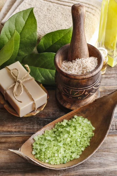Green sea salt and bar of natural handmade soap on wooden table — Stock Photo, Image