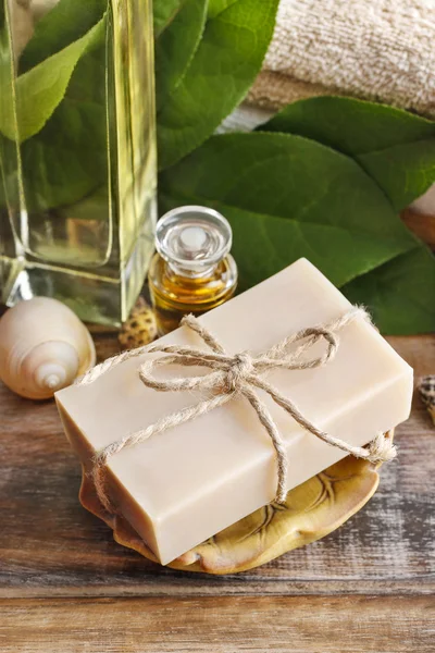 Bar of natural handmade soap and bottle of essential oil — Stock Photo, Image