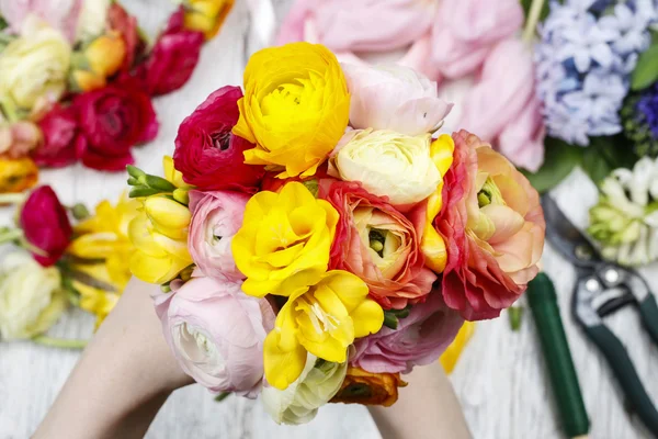 Frau macht Strauß aus persischen Hahnenfuß-Blumen — Stockfoto