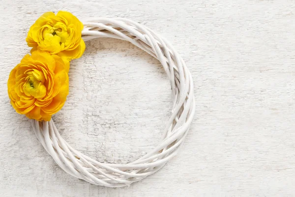 Wicker wreath decorated with yellow persian buttercup flowers (r — Stock Photo, Image