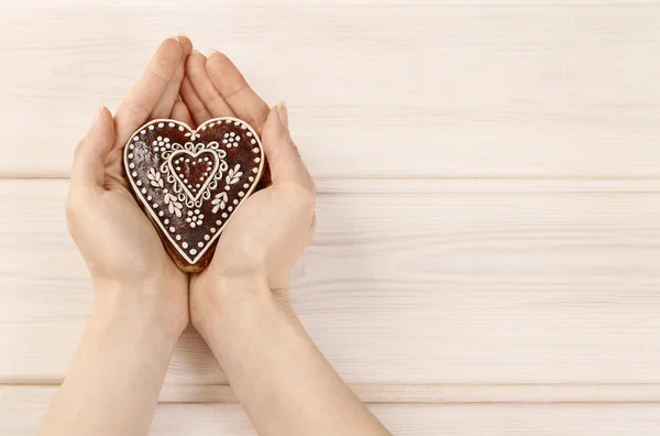 Woman holding gingerbread heart — Stock Photo, Image