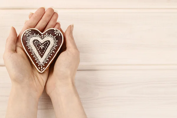 Woman holding gingerbread heart — Stock Photo, Image