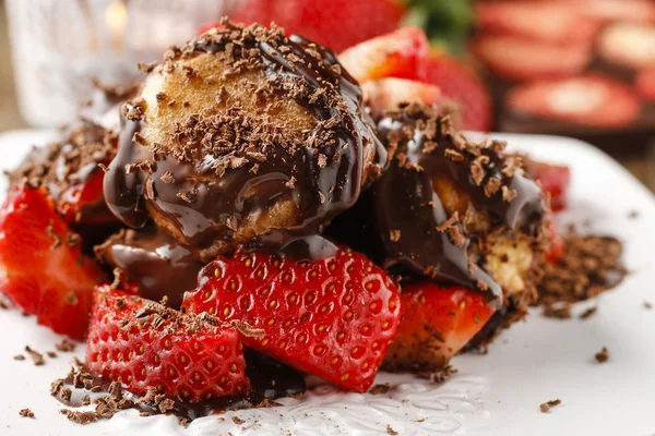 Profiteroles com morangos e molho de chocolate — Fotografia de Stock