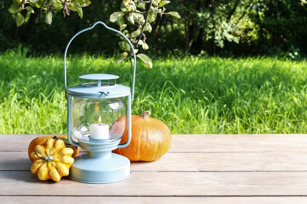 Lantern en pompoenen op houten tafel — Stockfoto