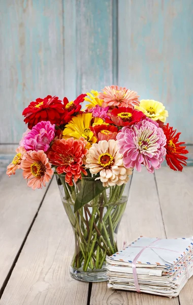 Bouquet of zinnia flowers and pile of vintage letters — Stock Photo, Image