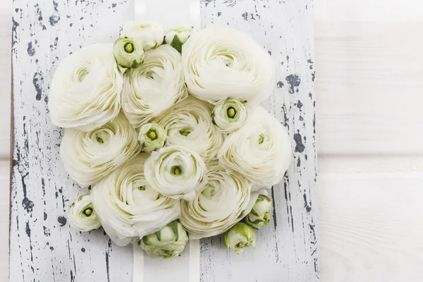 Witte ranunculus bloemen op witte houten achtergrond. — Stockfoto