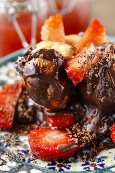 Profiteroles con fresas y salsa de chocolate —  Fotos de Stock