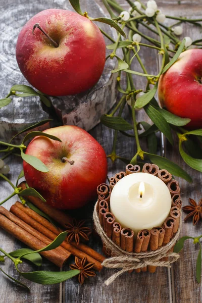 Candle decorated with cinnamon sticks, apples and mistletoe — Stock Photo, Image