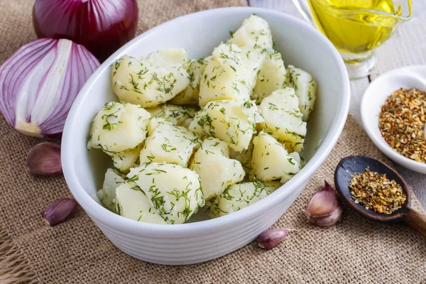 Bowl of boiled potatoes, fresh vegetables and herbs around — Stock Photo, Image