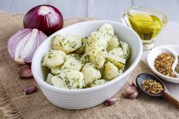 Bowl of boiled potatoes, fresh vegetables and herbs around — Stock Photo, Image