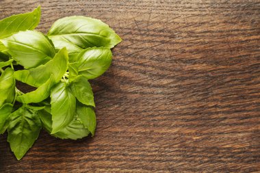 Ahşap arka planda fesleğen yaprakları.