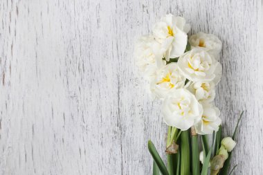 Ahşap arka plan üzerinde beyaz nergis çiçekleri