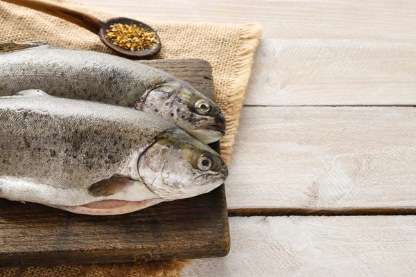 To regnbueørret på et landlig trebord – stockfoto